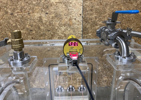 Digital vacuum gauge and controller displaying absolute pressure on a benchtop vacuum system